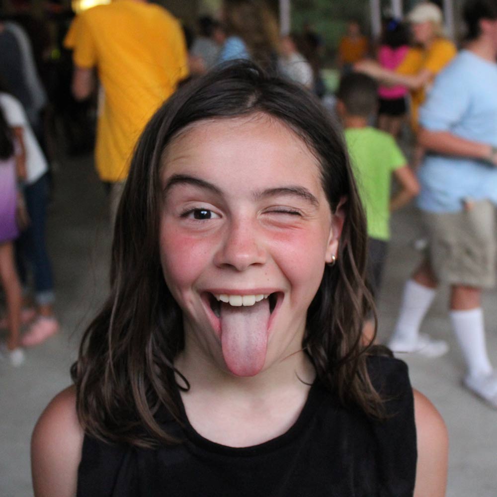 young girl sticking tongue out and winking